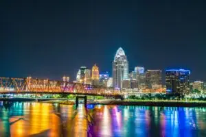 Captivating view of Cincinnati Ohio skyline with bridge reflections on Ohio River at night.