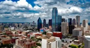 A stunning panoramic view of the Dallas skyline under dramatic clouds, capturing the city's iconic skyscrapers.