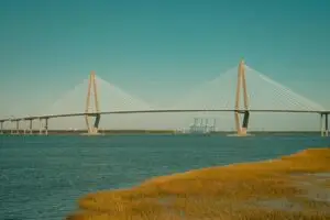 A picturesque view of the Arthur Ravenel Jr. Bridge spanning across a serene river under a clear sky.